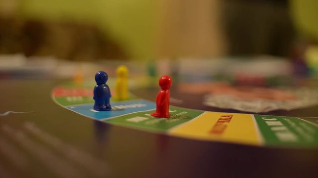 Board Game Cash Flow - a player throws the dice on the field and makes his move