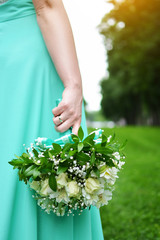 Wedding bouquet in the hand of the bride. Free space. Florist. Happiness. Fresh flowers. Blurred background.