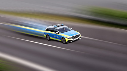 Polizeiauto im Einsatz fahrend auf mit hoher Geschwindigkeit