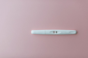 The white negative pregnancy test on the light pink background. Copy space