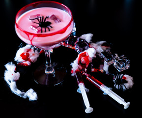 creepy halloween party cocktails with blood, spiders and ice cubes