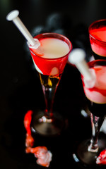 creepy halloween party cocktails with blood, spiders and ice cubes