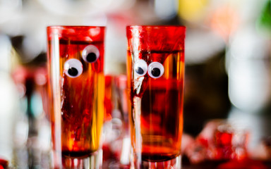 creepy halloween party cocktails with blood, spiders and ice cubes
