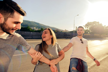 SPIRIT OF YOUTH. GROUP OF THREE CAREFREE FRIEND TAKE A LEISURELY WALK