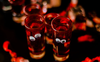 creepy halloween party cocktails with blood, spiders and ice cubes