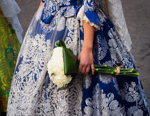 detalle de traje de fallera bordado a mano y ramo de flores que se utiliza para realizar la ofrenda...