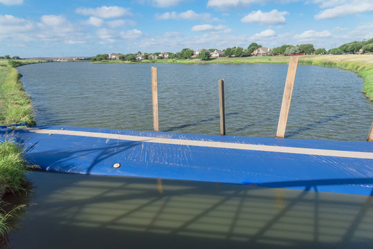 Inflatable dam near a lakeside residential neighborhood in Irving, Texas, USA. Water filled cylindrical tubes act as rubber temporary, industrial grade geo-textile material barrier
