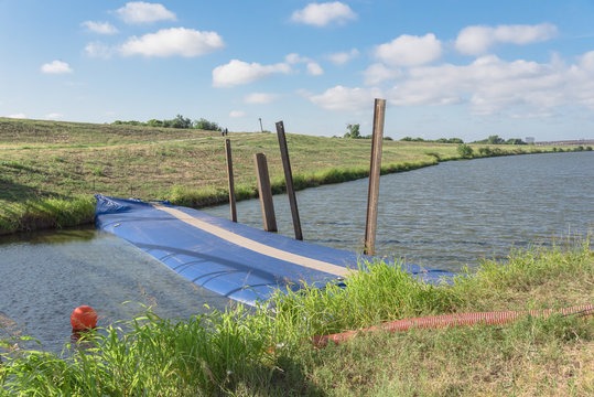 Inflatable dam, water inflated flood barrier at civil engineering projects in Irving, Texas, USA. Water filled cylindrical tubes act as rubber temporary, industrial grade geo-textile material dam