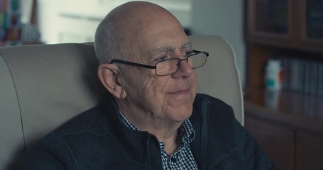 Senior man sitting in armchair in living room