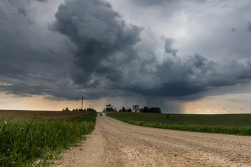 Truck Driving Down Country Road Away From Storm