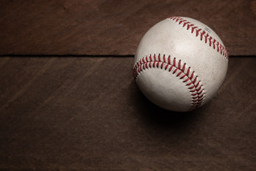 A group of vintage baseball equipment, bats, gloves, baseballs on wooden background