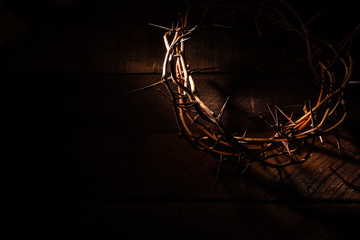 An authentic crown of thorns on a wooden background. Easter Theme - obrazy, fototapety, plakaty