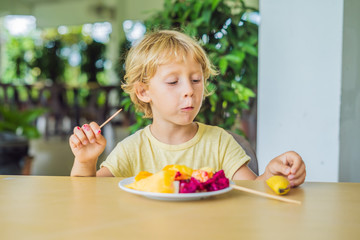 portrait of smiling little boy looking at camera during breakfast on the terrace