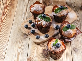 Obraz na płótnie Canvas Muffins with blueberries on a wooden background. homemade baking