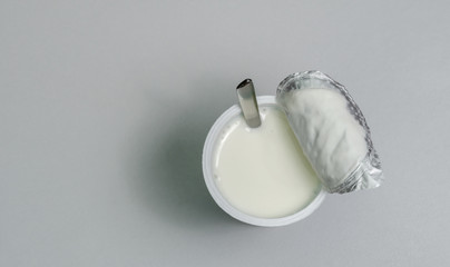 Top view of Plastic container set of yogurt with spoon on white background