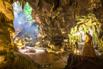 People or tourists, worship the Buddha statue with sun light in the cave at Khaoluang,Phetchaburi Province, Thailand. This place is a public place. People have access.