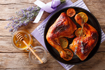 Delicious food: grilled glazed chicken legs with lavender honey and lemon close-up on a plate....