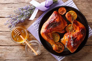  Delicious food: grilled glazed chicken legs with lavender honey and lemon close-up on a plate. horizontal top view © FomaA