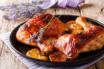 Spicy grilled glazed chicken legs with lavender and lemon close-up on a plate. French cuisine. horizontal