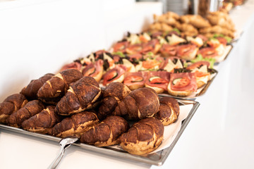 many delicious croissant bread stacked on a buffet line