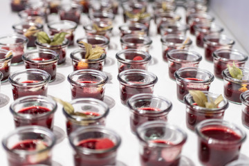 Closeup many dessert jar rowed up on buffet table with fresh fruits jelly and cream