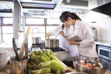 注意深く鍋の中を覗く栄養士たち