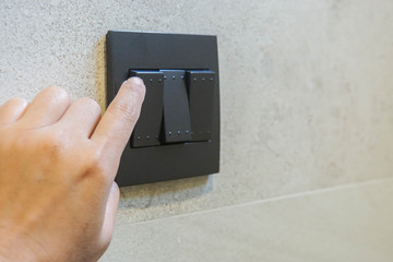 close up woman turn off light switch for energy savings