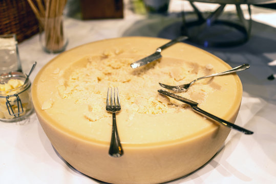 Big Wheel Of Parmesan Cheese On Counter Of Restaurant Self Service Table With Knife And Fork