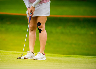 A Golfer practice to pushing golf ball to hole in golf competition