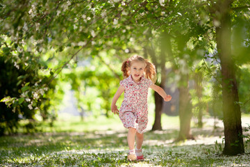 Naklejka premium Little cute girl walking in summer park