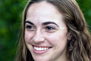 Portrait of young woman outside smiling in natural light
