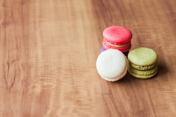 Colorful French Macarons on wooden background.