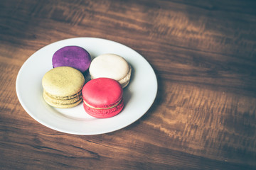 Colorful French Macarons on wooden background.