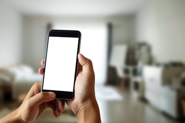 A man hand holding smart phone device in the bright office room interior.