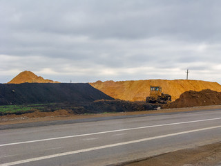 View on road construction site with bulldozer on roadside