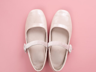 Pair of ballet shoes on pink background with copy space.