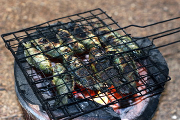 grilled fish, thai food style Cooking Grilled Climbing perch Fish on Grate on charcoal stove, asia fish food, (Anabas testudineus)