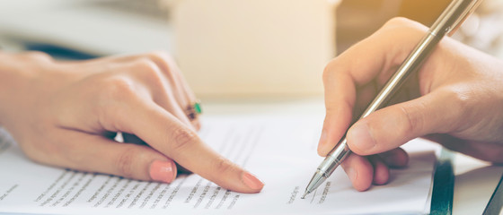 Businesswoman signs agreement contract in office.
