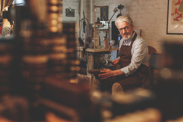 An elderly shoemaker in a studio