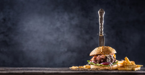 Close-up home made beef burger with knife and fries on wooden table - obrazy, fototapety, plakaty