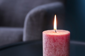 Burning wax candle on blurred background