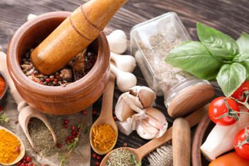 Different kinds of spices with vegetables on wooden table