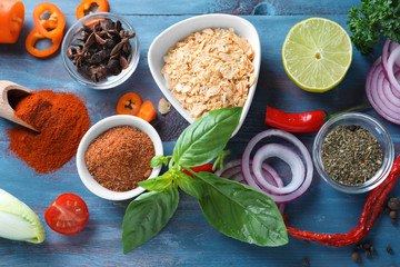 Various spices with vegetables on wooden background