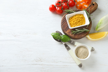Various spices with herbs and vegetables on wooden background