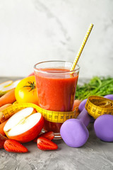 Glass of fresh tasty smoothie with ingredients, dumbbells and measuring tape on table. Weight loss concept
