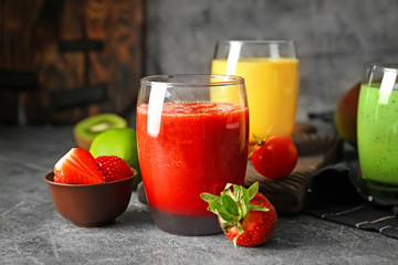 Glasses with fresh tasty smoothies and ingredients on table