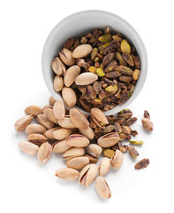 Bowl with pistachio nuts on white background
