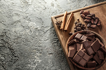 Composition with tasty milk chocolate on grey textured background