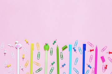pink background with various School accessories are laid out in the form of a rainbow