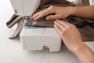 Obraz na płótnie Canvas Female tailor working on sewing machine in atelier